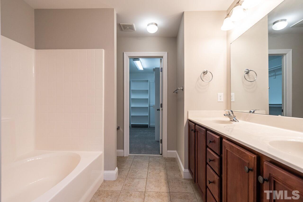 524 Bouree Circle Raleigh, NC 27606 - Photo 24 of 34 a bathroom with a tub sink and mirror