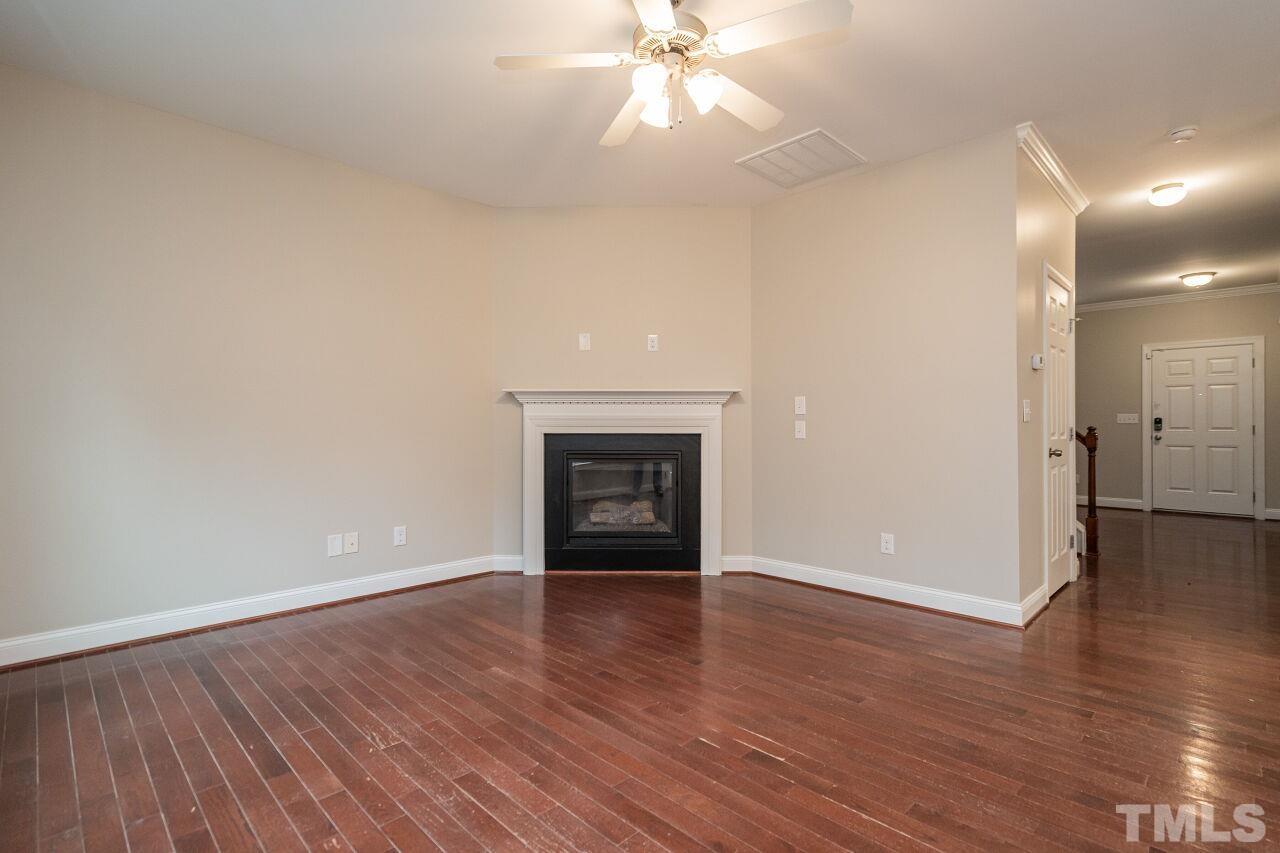 524 Bouree Circle Raleigh, NC 27606 - Photo 9 of 34 a view of an empty room with wooden floor and a fireplace