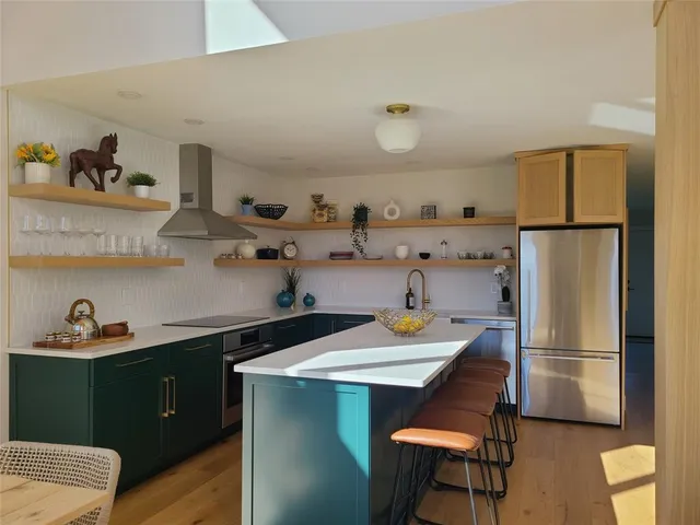 a kitchen with a refrigerator and a wooden floor