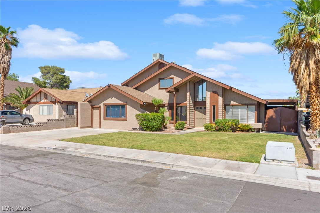 4430 Cranbrook Way Las Vegas, NV 89103 - Photo 2 of 50 A desert oasis awaits with this residence, featuring a lush lawn and a striking facade.