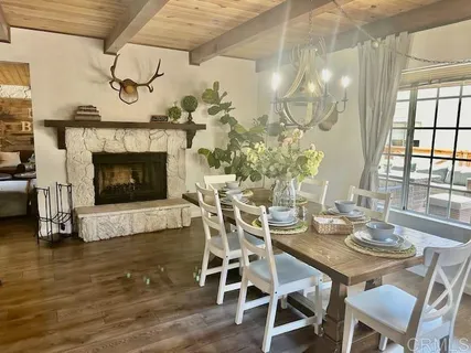 a dining room with furniture a fireplace and wooden floor