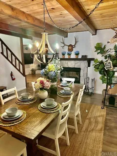 a dining room with furniture a chandelier and wooden floor