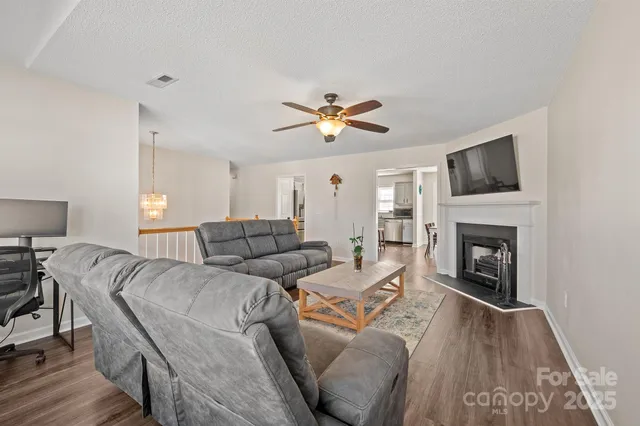 a living room with furniture a fireplace and a flat screen tv