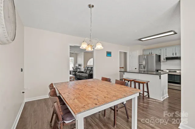 a kitchen with a table chairs refrigerator and cabinets