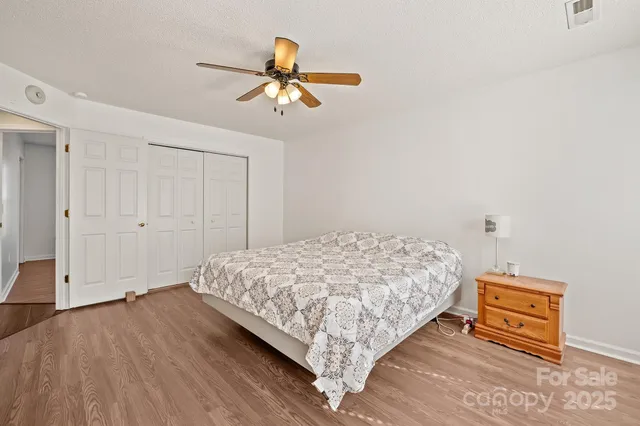 a bedroom with a bed and a flat tv screen on dresser