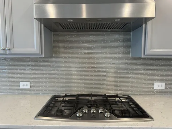 a stove top oven sitting inside of a kitchen