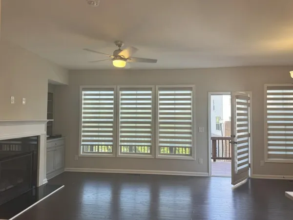an empty room with windows and fireplace