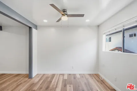 a view of room with a ceiling fan and wooden floor