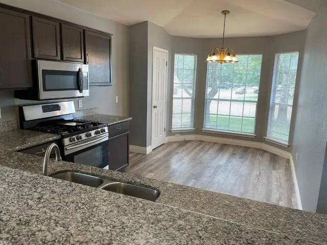 a kitchen with a stove a sink and a window