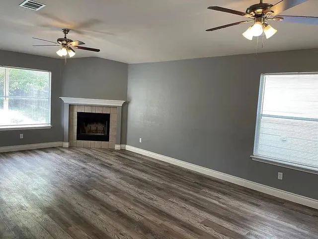 a view of an empty room with a fireplace and a window