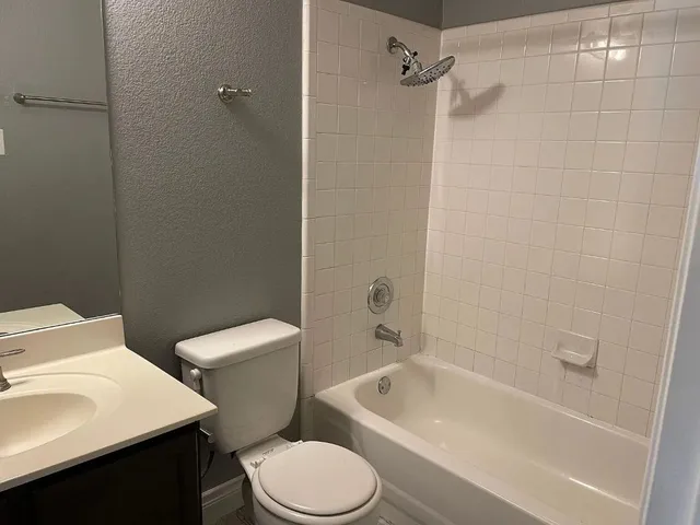 a white toilet sitting next to a bath tub