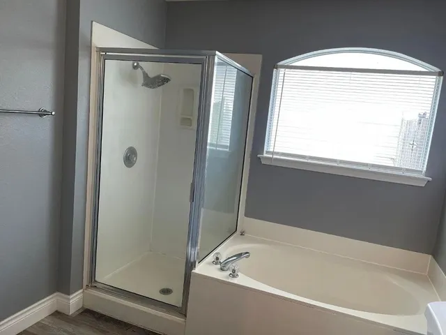 a white bath tub sitting next to a shower