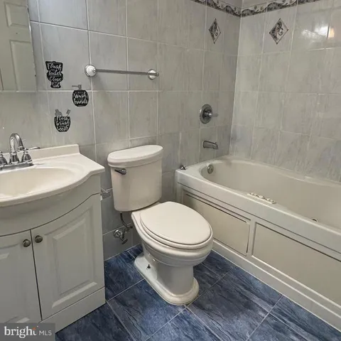a white toilet sitting next to a bath tub