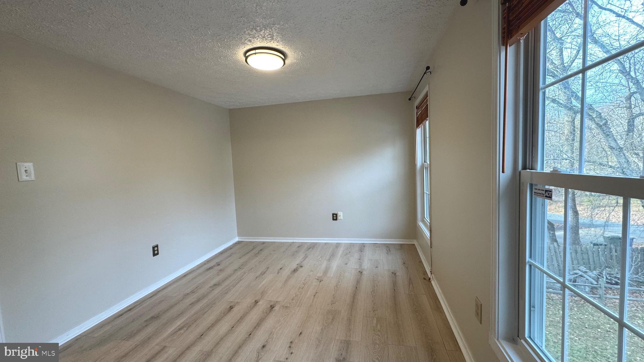 18817 Kerill Road Triangle, VA 22172 - Photo 12 of 23 a view of an empty room with wooden floor and a window