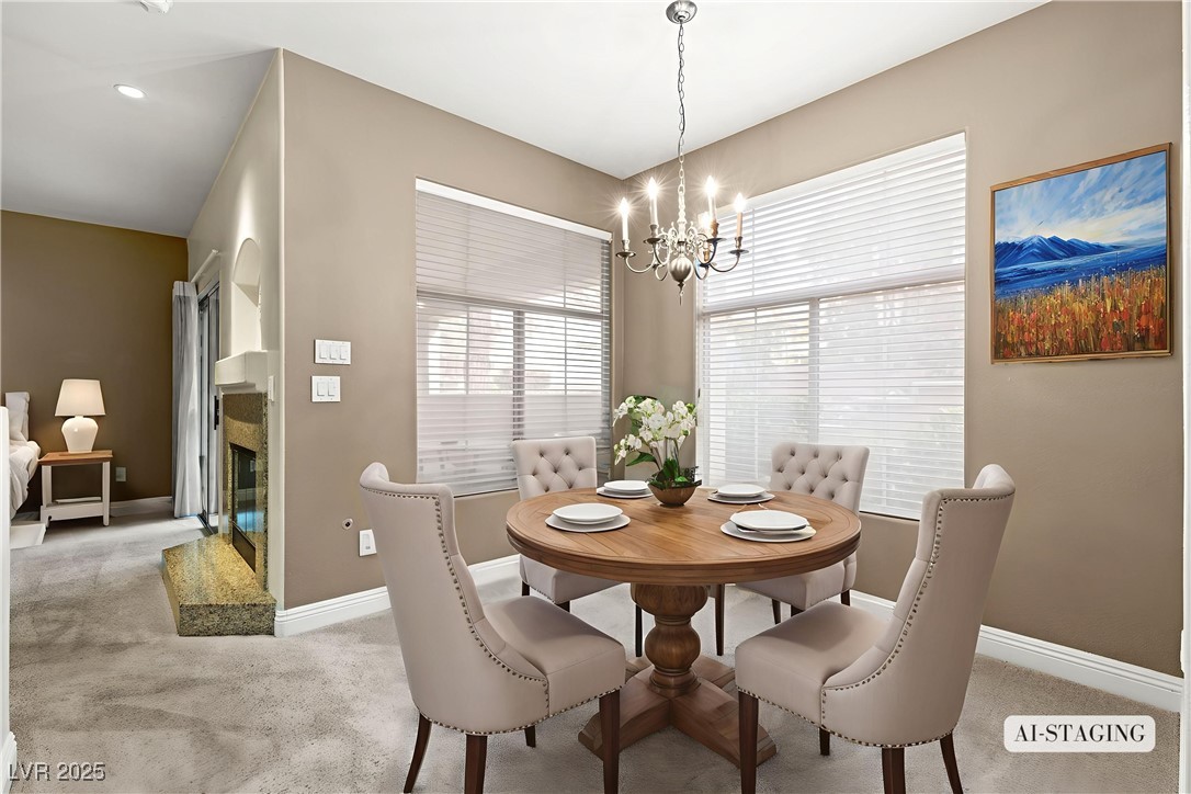 2050 West Warm Springs Road, Unit 3311 Henderson, NV 89014 - Photo 16 of 48 Dining area featuring carpet floors, a fireplace, and a chandelier