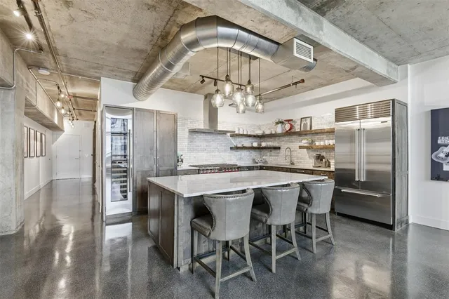 a kitchen with stainless steel appliances a table chairs and entryway