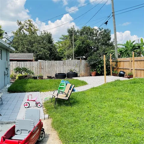 a view of a house with backyard and a tree
