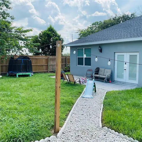 a view of yard with swimming pool and trees