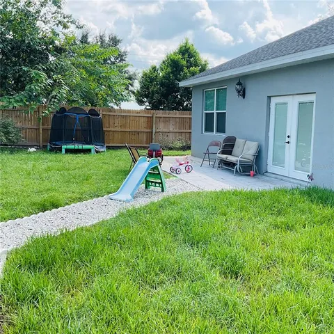 a view of a backyard with plants and wooden fence