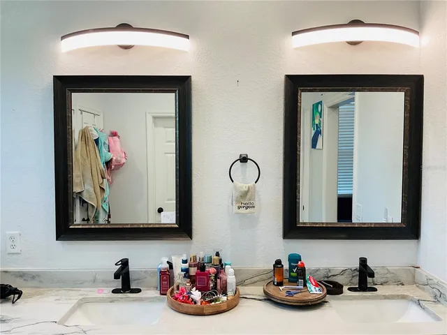 a kitchen with kitchen island granite countertop stainless steel appliances a sink a stove a refrigerator cabinets and chairs