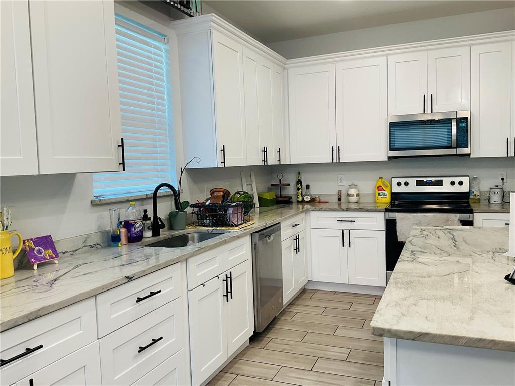 515 5th Street South Dundee, FL 33838 - Photo 48 of 74 a kitchen with granite countertop white cabinets sink and stainless steel appliances