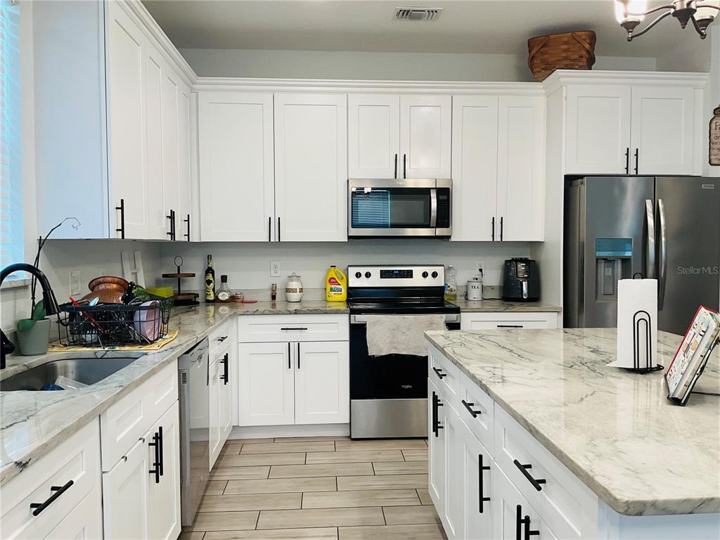 515 5th Street South Dundee, FL 33838 - Photo 49 of 74 a kitchen with stainless steel appliances granite countertop a sink a stove a refrigerator and white cabinets