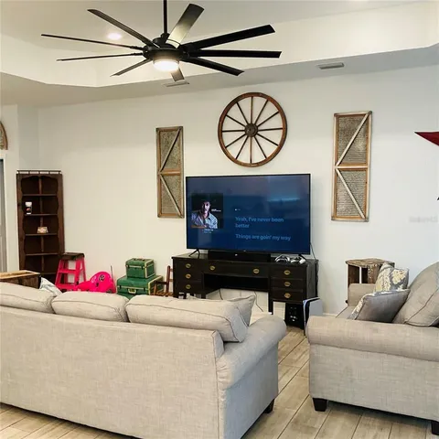 a living room with furniture and a ceiling fan