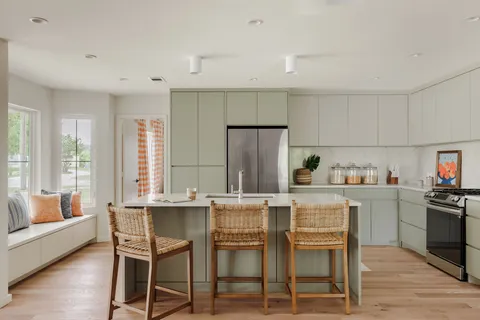 a kitchen with a table chairs refrigerator and cabinets
