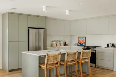 a kitchen with a dining table chairs and appliances