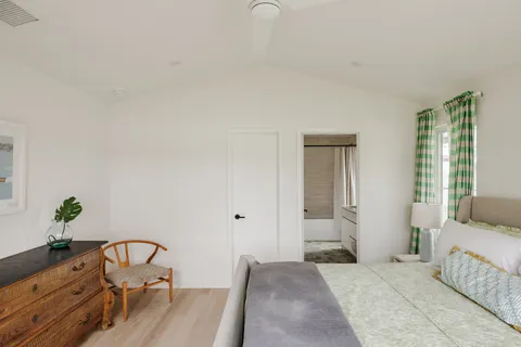 a view of a bedroom with a bed and wooden floor