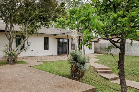 a front view of a house with a yard and trees