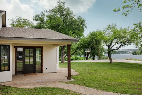 a view of a house with backyard and a tree