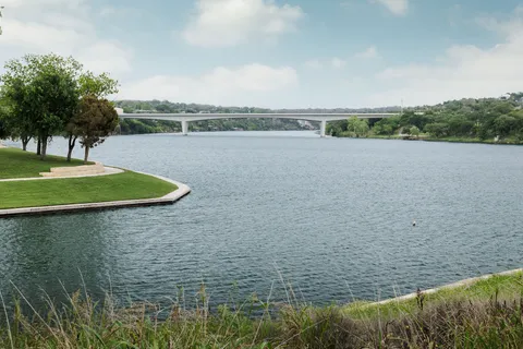 a view of a lake with outdoor space and large trees