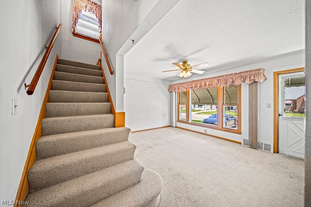 1738 Rockefeller Road Wickliffe, OH 44092 - Photo 18 of 35 Stairway featuring light colored carpet, ceiling fan, and a textured ceiling