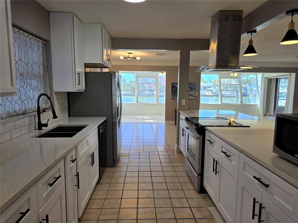 530 Lillian Drive Madeira Beach, FL 33708 - Photo 23 of 56 a kitchen with a sink stove and cabinets