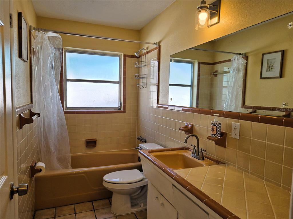 530 Lillian Drive Madeira Beach, FL 33708 - Photo 33 of 56 a bathroom with a sink a toilet a mirror and shower