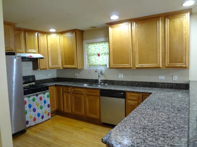 a kitchen with stainless steel appliances granite countertop a sink stove and cabinets