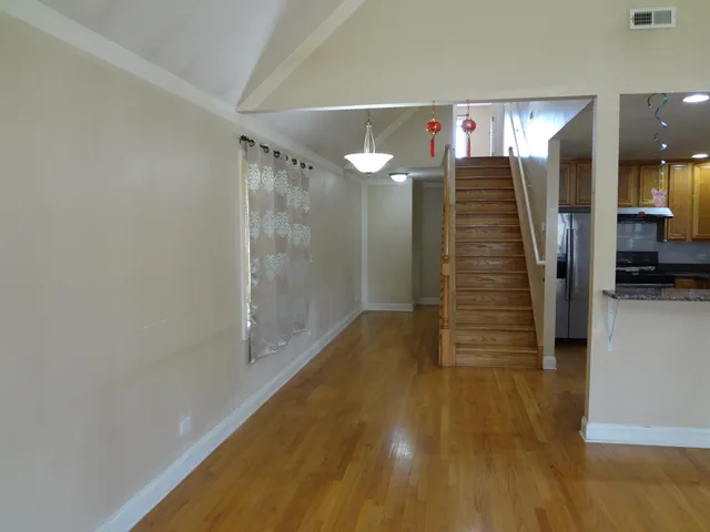 a view of a hallway with wooden floor and staircase