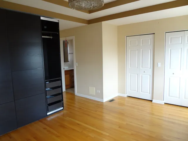 a view of empty room with wooden floor and closet