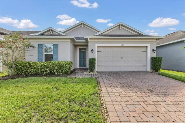 a view of a house with a yard and potted plants