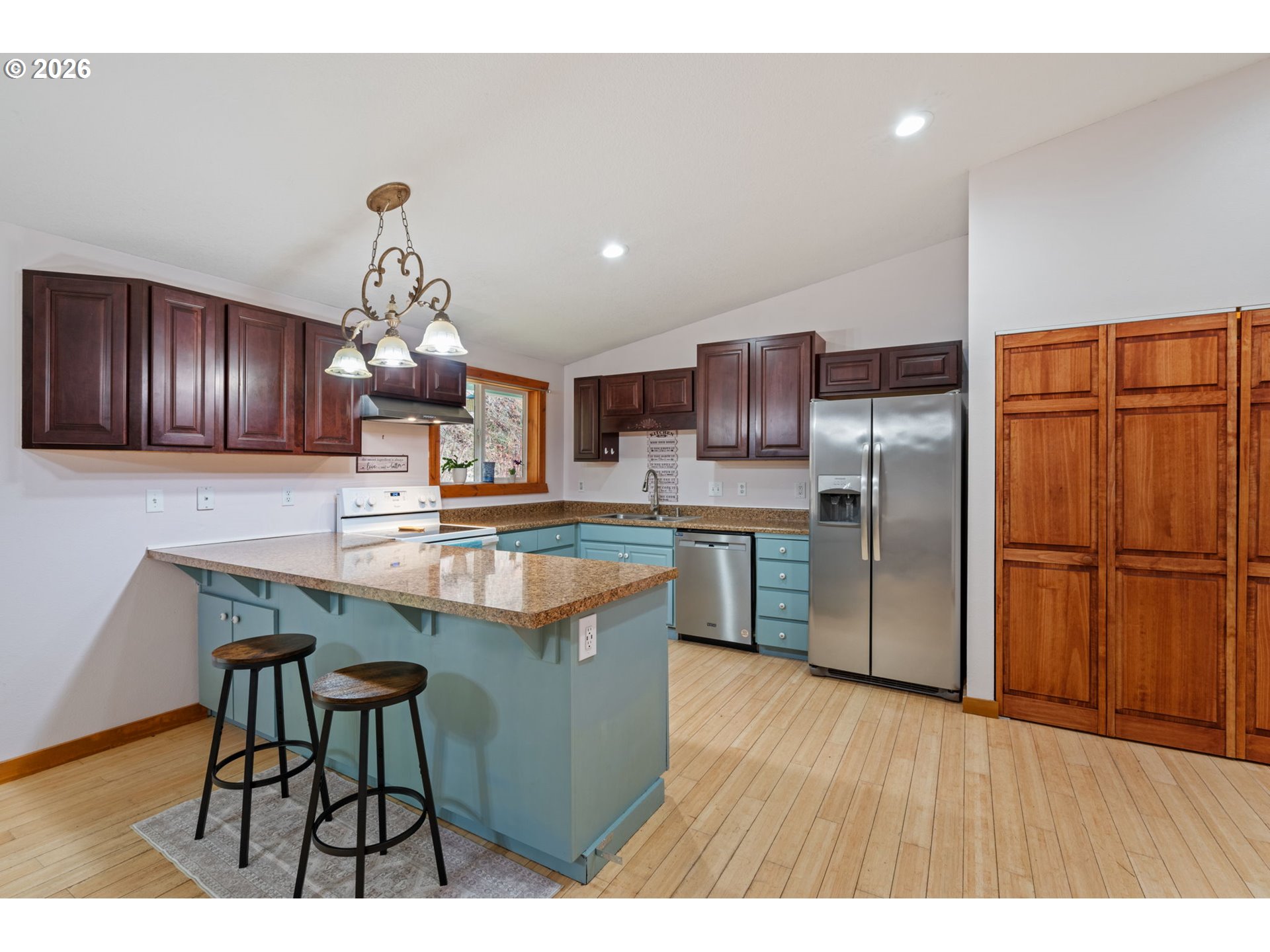 38220 Northeast Sunset Falls Road Yacolt, WA 98675 - Photo 12 of 40 a kitchen with stainless steel appliances kitchen island granite countertop a table chairs and a refrigerator