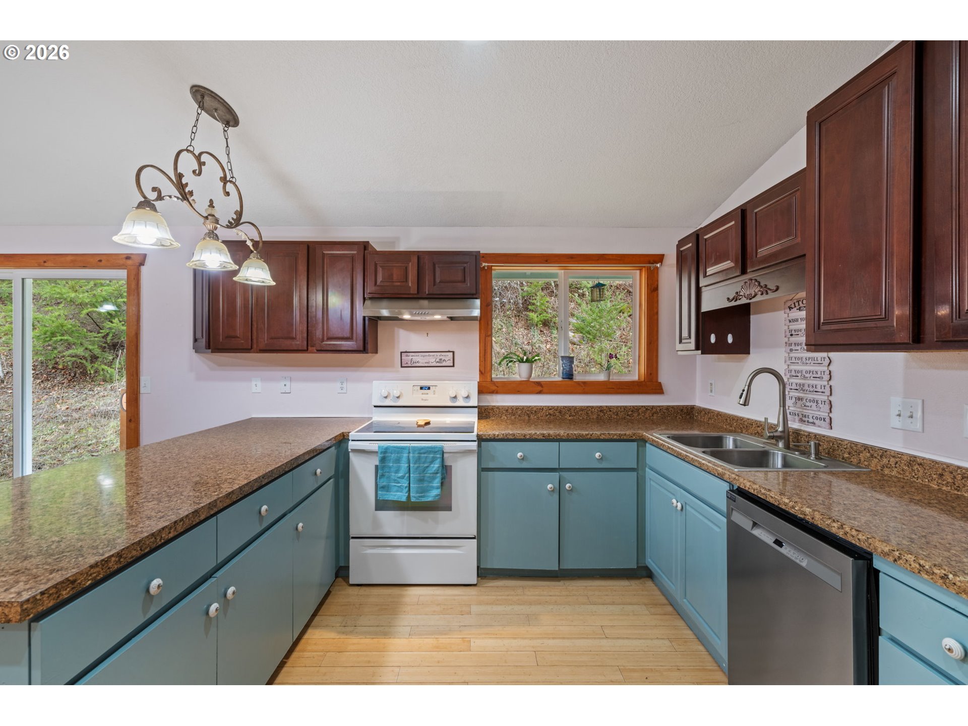 38220 Northeast Sunset Falls Road Yacolt, WA 98675 - Photo 13 of 40 a kitchen with stainless steel appliances granite countertop a sink a stove cabinets counter space and a window