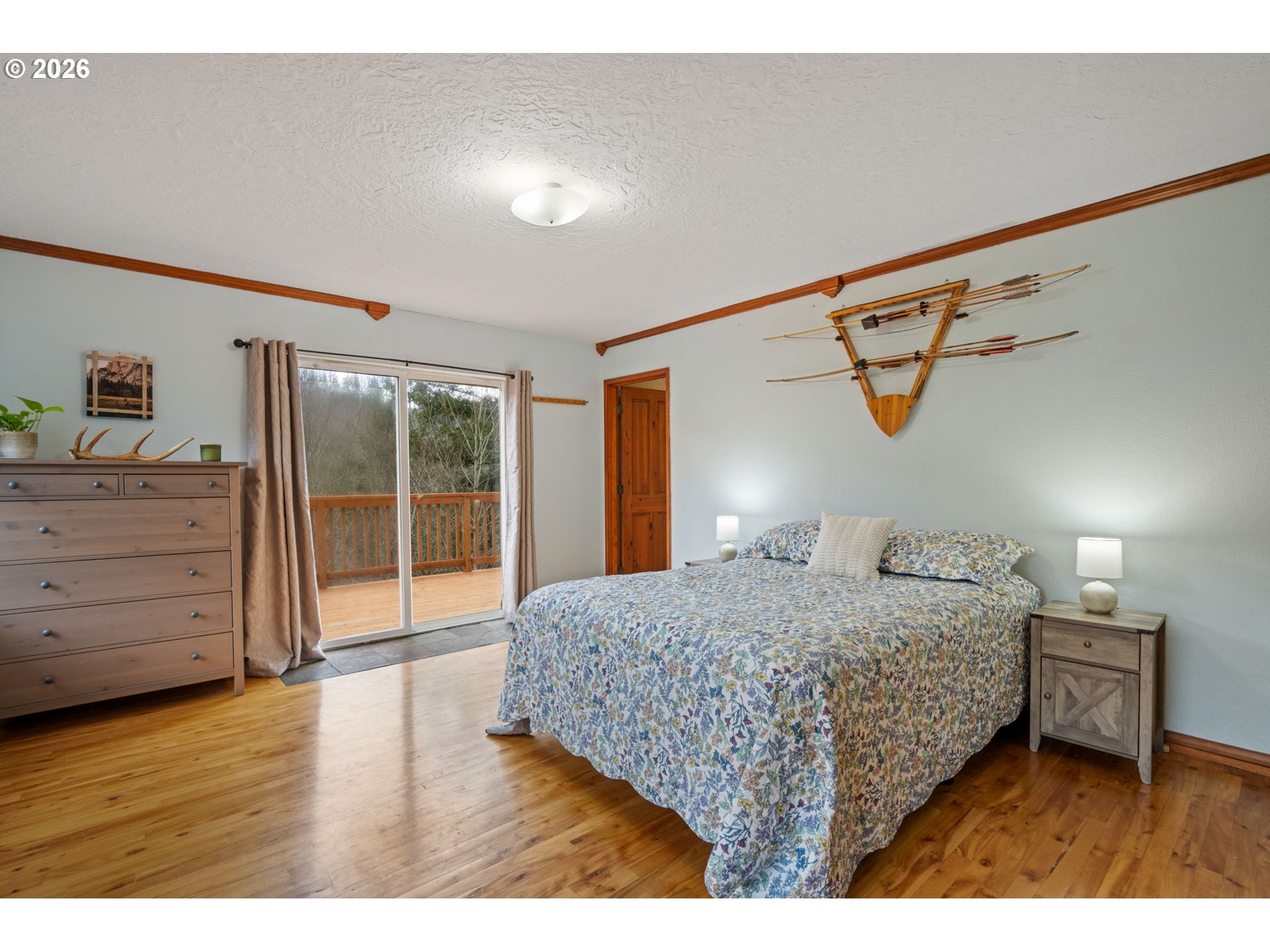 38220 Northeast Sunset Falls Road Yacolt, WA 98675 - Photo 22 of 40 a bedroom with a bed a dresser with wooden floor