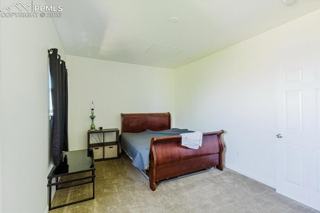 5800 Tower Road, Unit 108 Denver, CO 80249 - Photo 10 of 34 Carpeted interior room featuring a window with dark drapes, white walls, and a white paneled door
