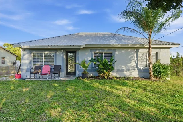 a view of a house with a porch and a yard