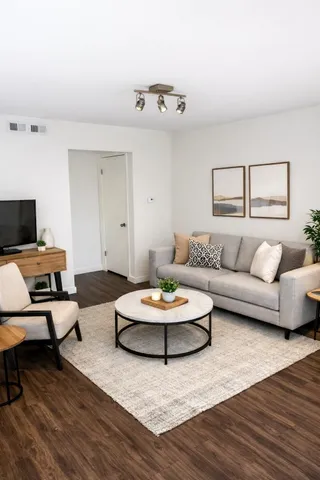 a living room with furniture and a wooden floor