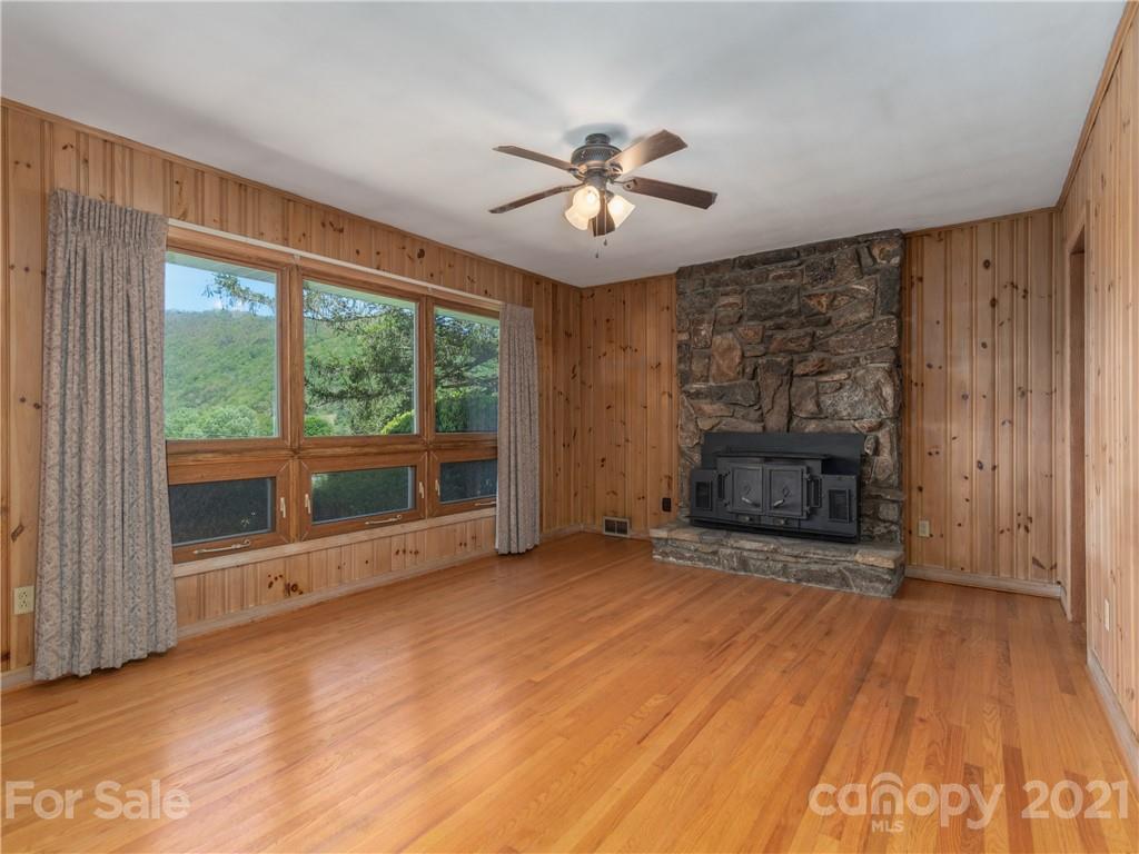 113 Possum Ridge Road Canton, NC 28716 - Photo 4 of 24 a view of an empty room with a fireplace and a window
