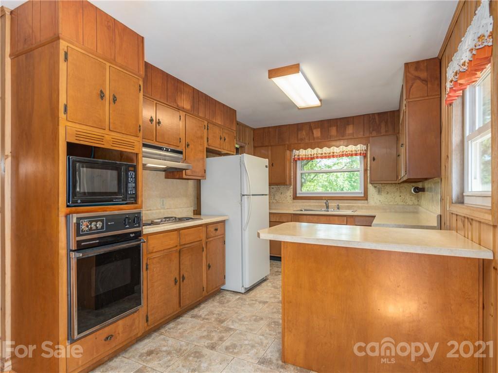 113 Possum Ridge Road Canton, NC 28716 - Photo 6 of 24 a kitchen that has a sink a stove and a refrigerator