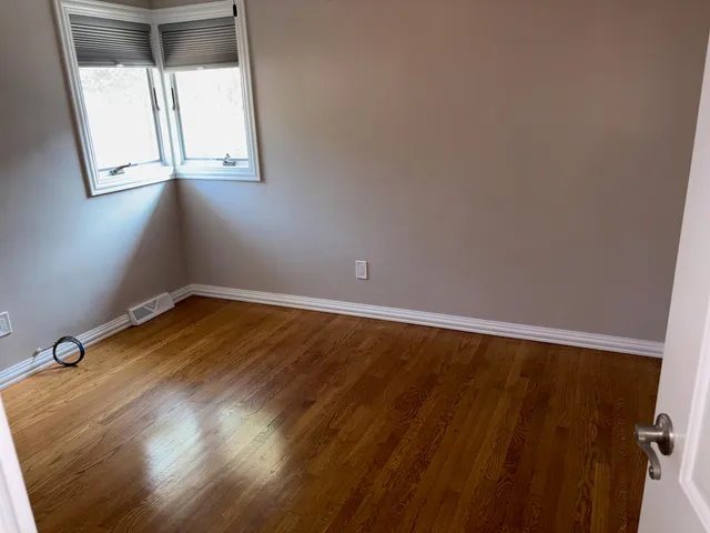 a view of a room with wooden floor and windows