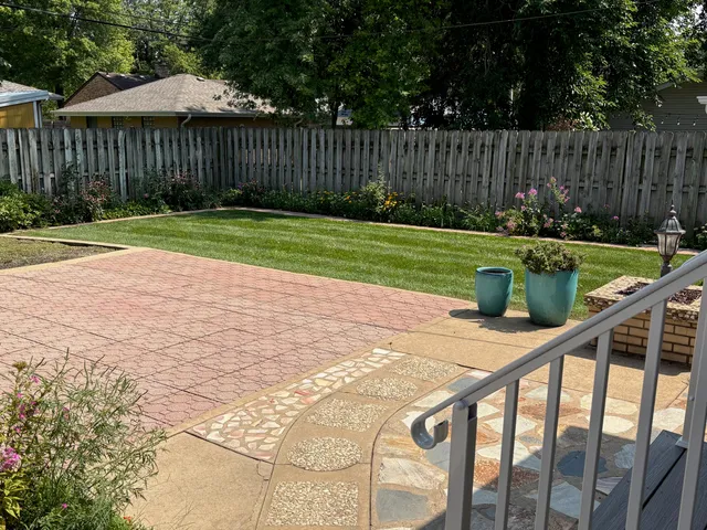a view of backyard with wooden fence and trees
